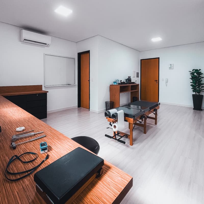 Sala de atendimento da Axium, com maca e equipamentos de avaliação